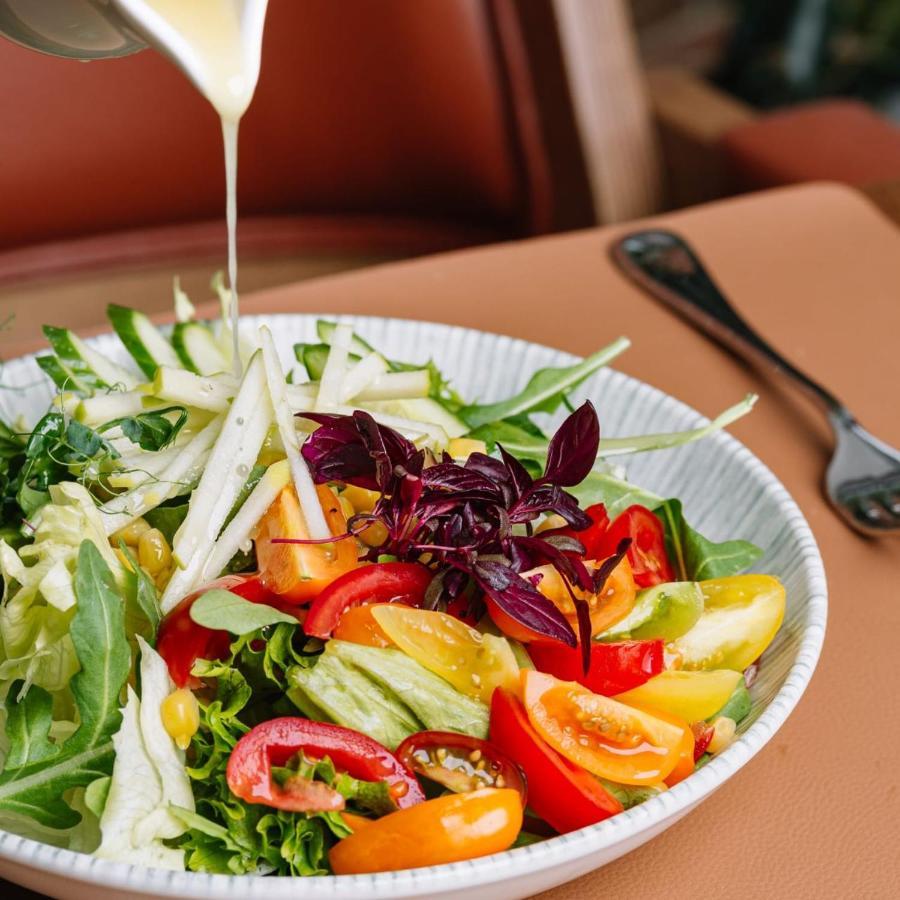 Royal Tulip Hotel & Casino, Tbilisi Bagian luar foto A salad being drizzled with a vinaigrette